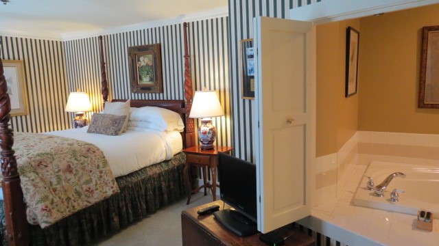 Bedroom and bathroom with large bathtub at Inn at Ormsby Hill